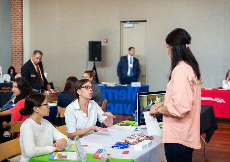 student interacts with employers at career fair
